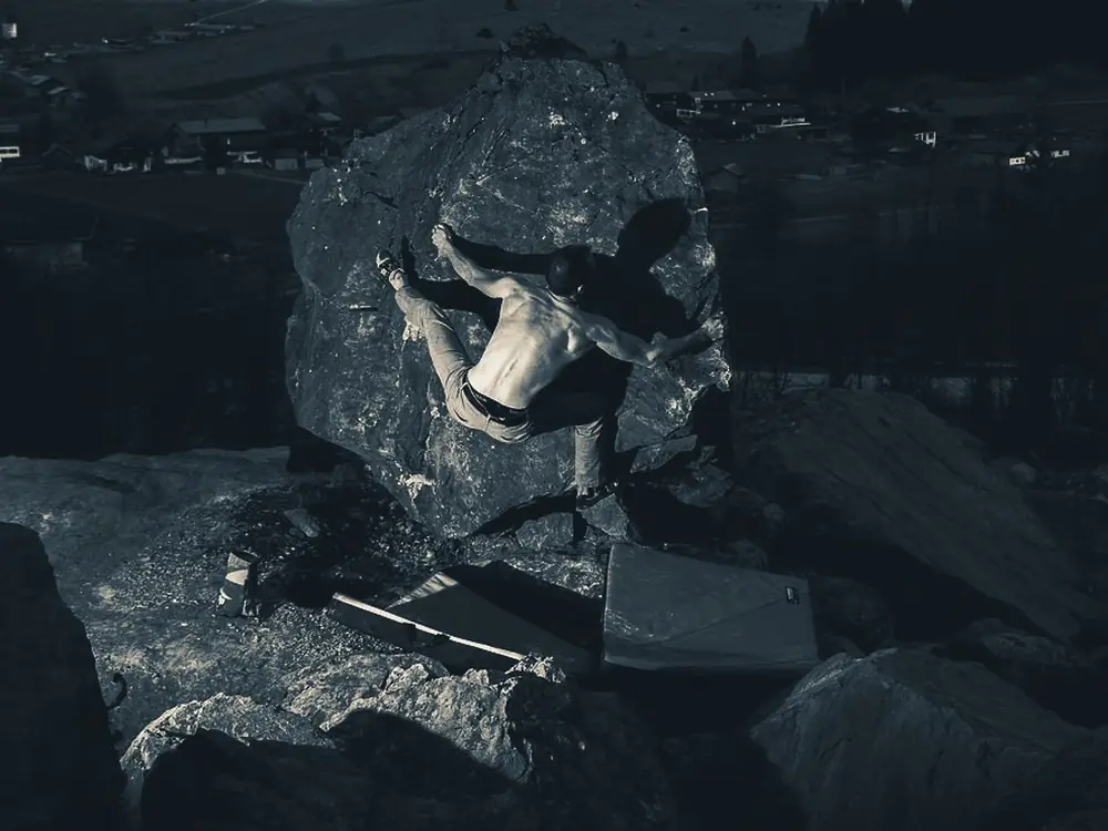 Boulderer am Fels, darunter zwei Crashpads